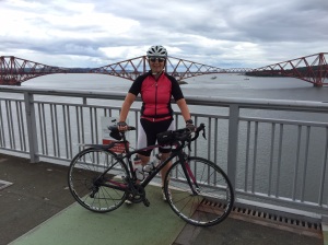 Me and my bike at the top of the Forth Road bridge with Forth rail bridge behind 